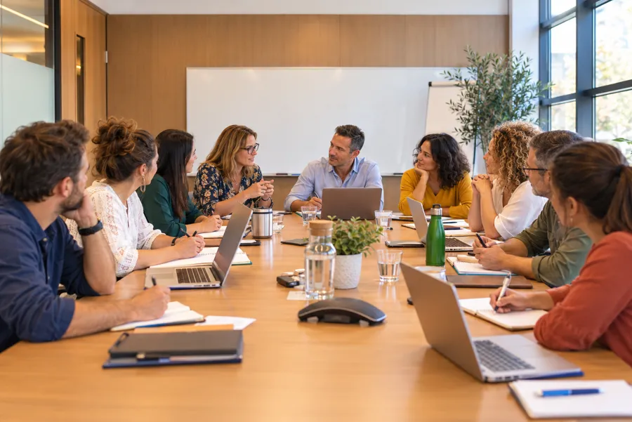 Illustration : une équipe en réunion de travail collectif autour d'une grande table